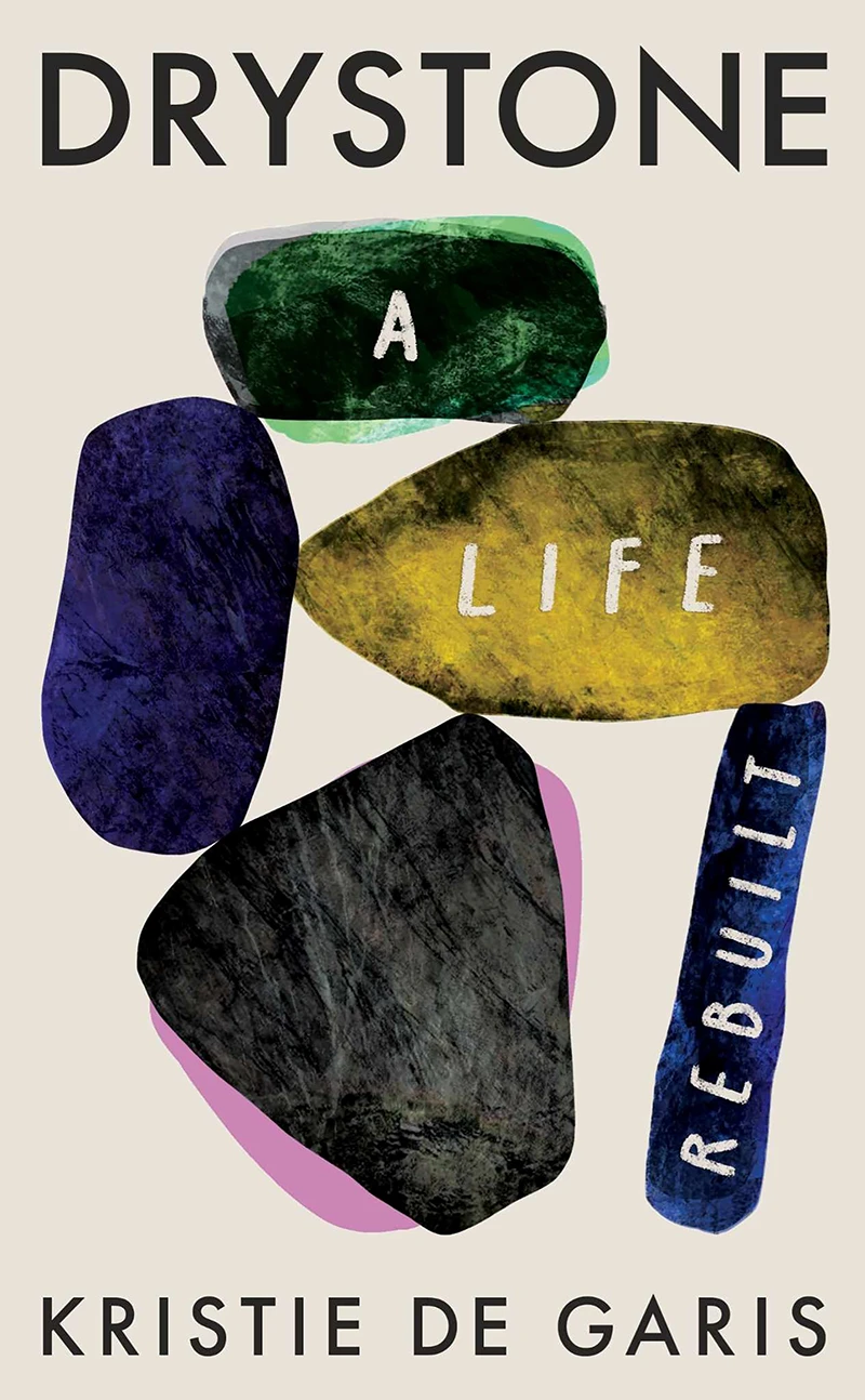 Book cover of Drystone: A Life Rebuilt by Kristie De Garis, featuring abstract painted stones arranged to form the title.