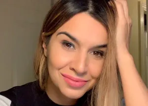 Fidan Meikle smiling at the camera with long highlighted hair and hand resting on her head.